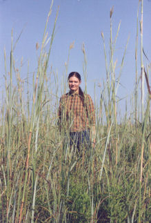 Julie Ward standing in a bluestem prairie